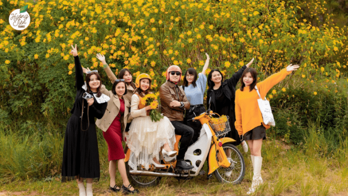 Group of tourists posing in front of wild sunflowers in Dalat, a scenic stop on the Dalat Land Tour by Huong Tien Tourist