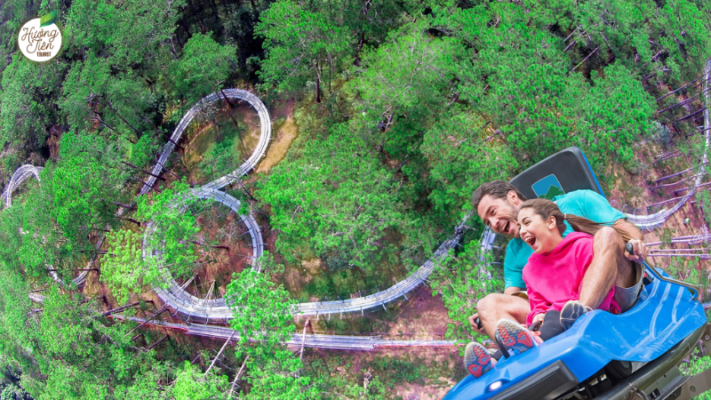 Family enjoying an exhilarating alpine coaster ride through Dalat's pine forest at Datanla Waterfall.