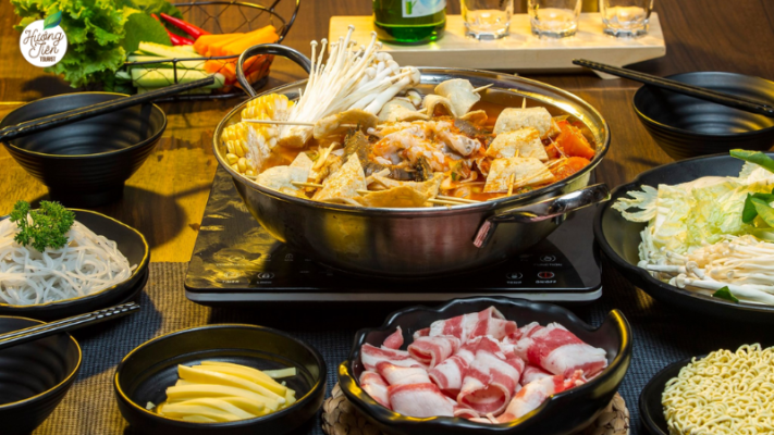 Traditional Vietnamese hotpot meal spread with fresh ingredients, enjoyed by visitors in Dalat.