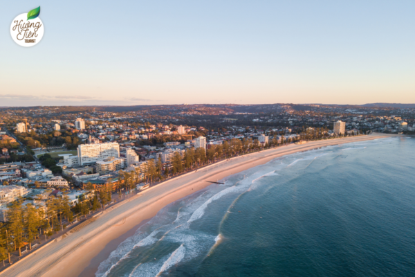 Bãi biển Manly trải dài với bờ cát mịn và làn sóng dịu dàng khi du lịch Sydney.