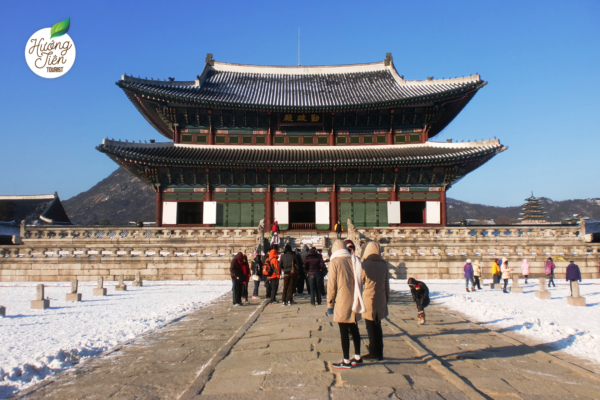 Cung điện Gyeongbok ở Seoul vào mùa đông, phủ tuyết trắng và có nhiều du khách thăm quan.