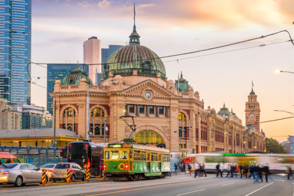 Cảnh hoàng hôn tại Ga Flinders với tòa nhà lịch sử và xe điện Melbourne, tạo nên một góc nhìn thơ mộng và quyến rũ.