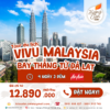 banner tour malaysia khởi hành từ đà lạt hành trình 4 ngày 3 đêm với dòng chữ "Vi vu malaysia" màu đỏ viền trắng. Hình nền tháp đôi petronas buổi sáng